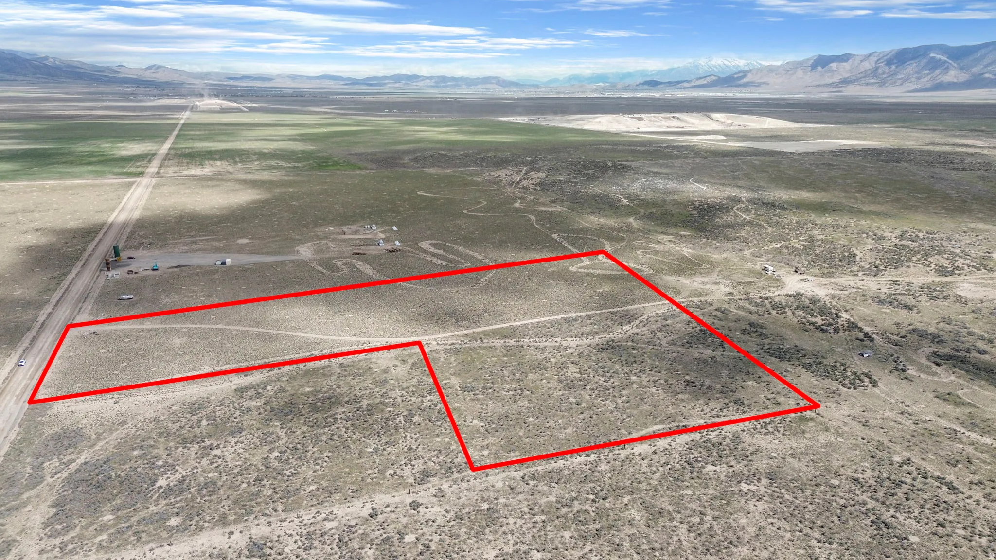 Expansive undeveloped land featuring a distinct boundary outline and direct road frontage
