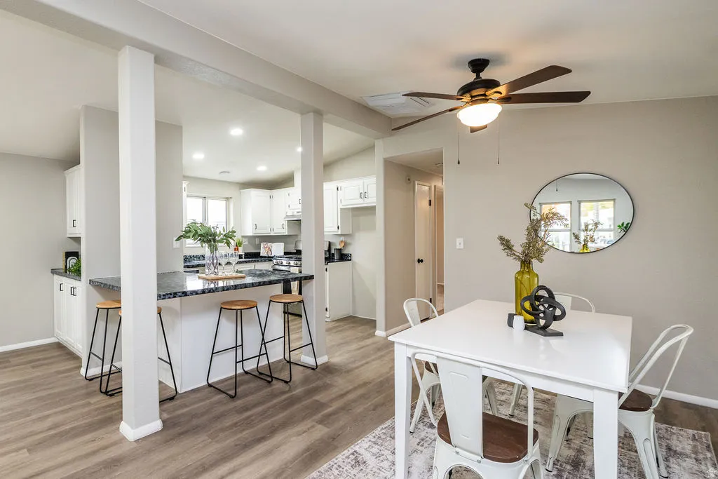 Dining area with dark wood-type flooring, vaulted ceiling, recessed lighting, and ceiling fan