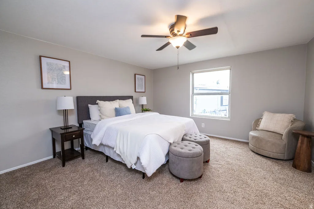 Bedroom featuring a ceiling fan and carpet