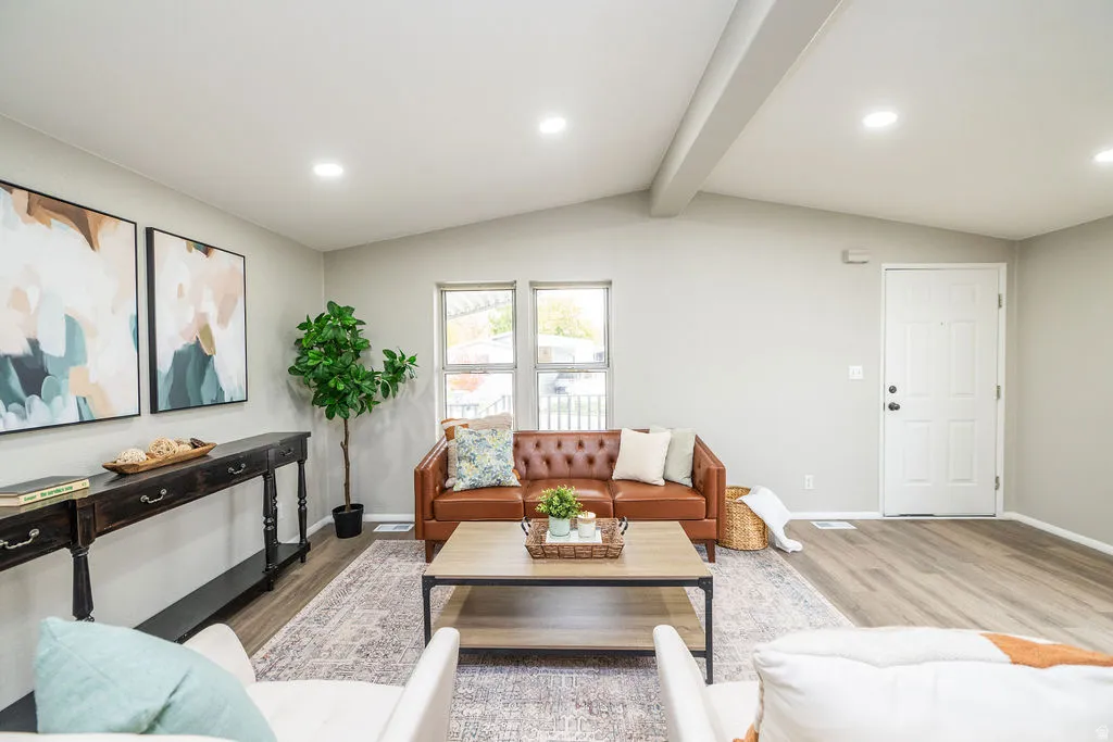 Living area with light wood-style flooring, recessed lighting, and beamed ceiling
