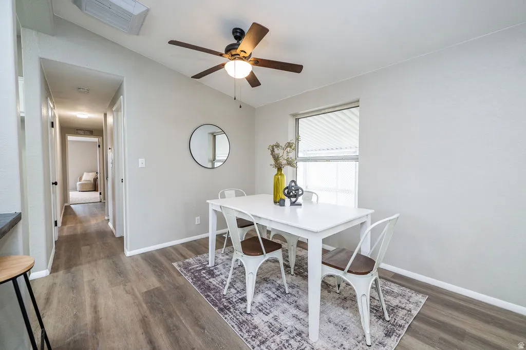 Dining area with vaulted ceiling, a ceiling fan, and dark wood-style floors