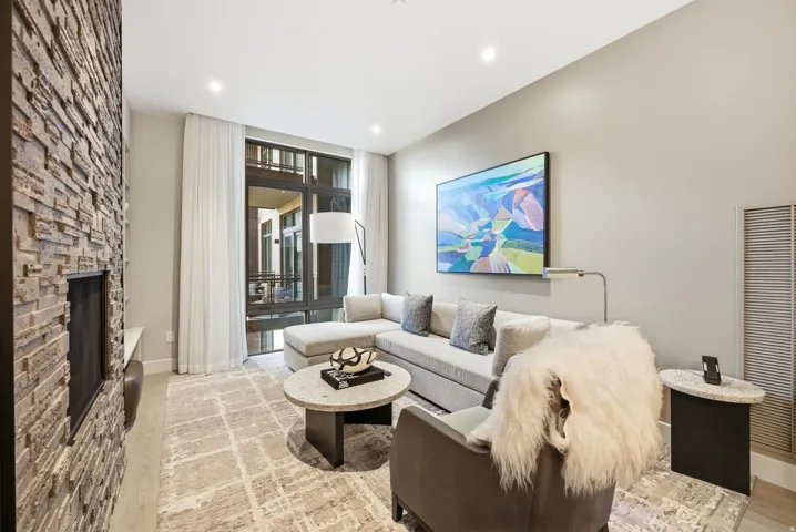 Living area with floor to ceiling windows, a heating unit, light wood-style floors, a fireplace, and recessed lighting