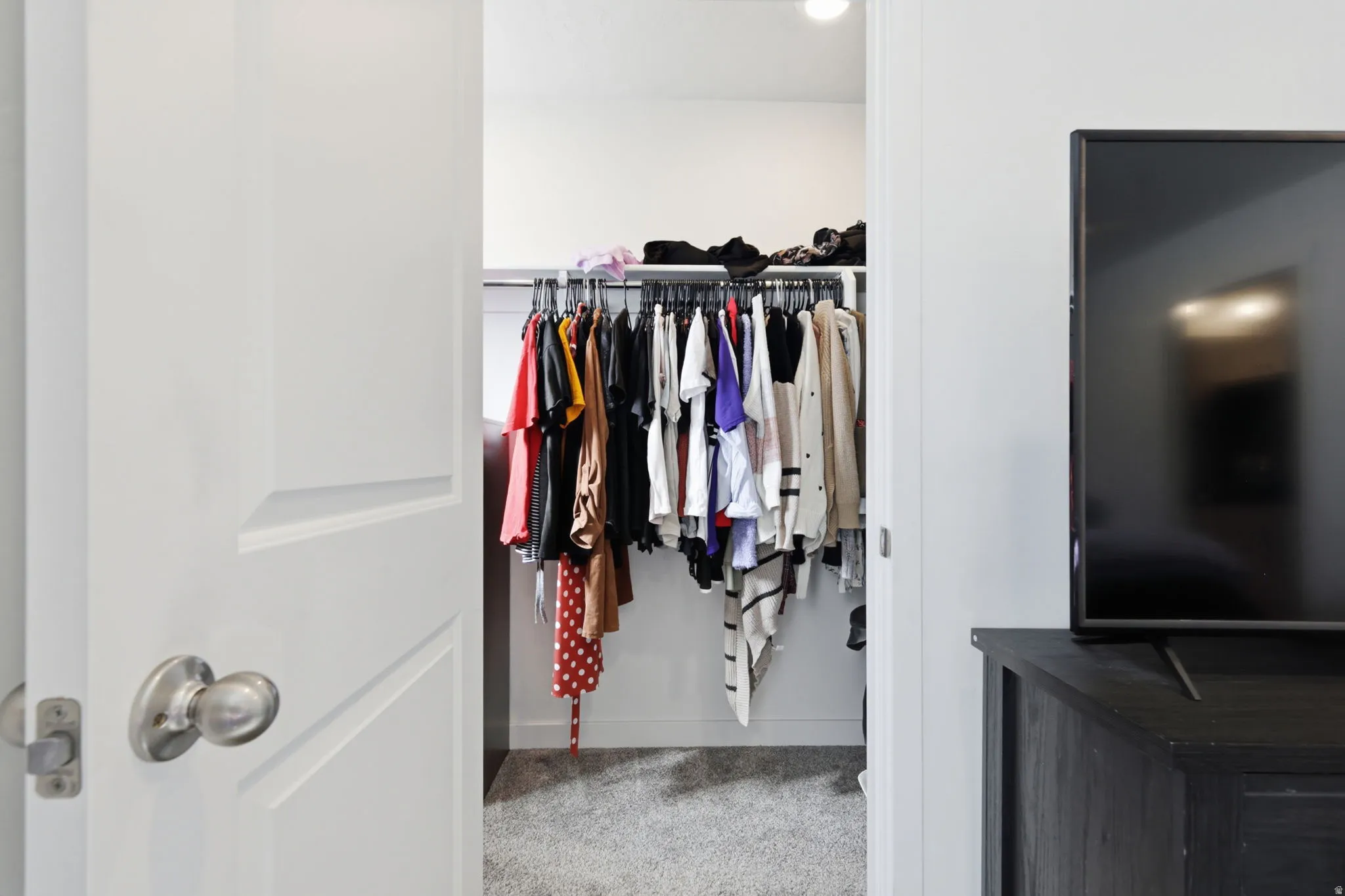 Walk in closet featuring light carpet