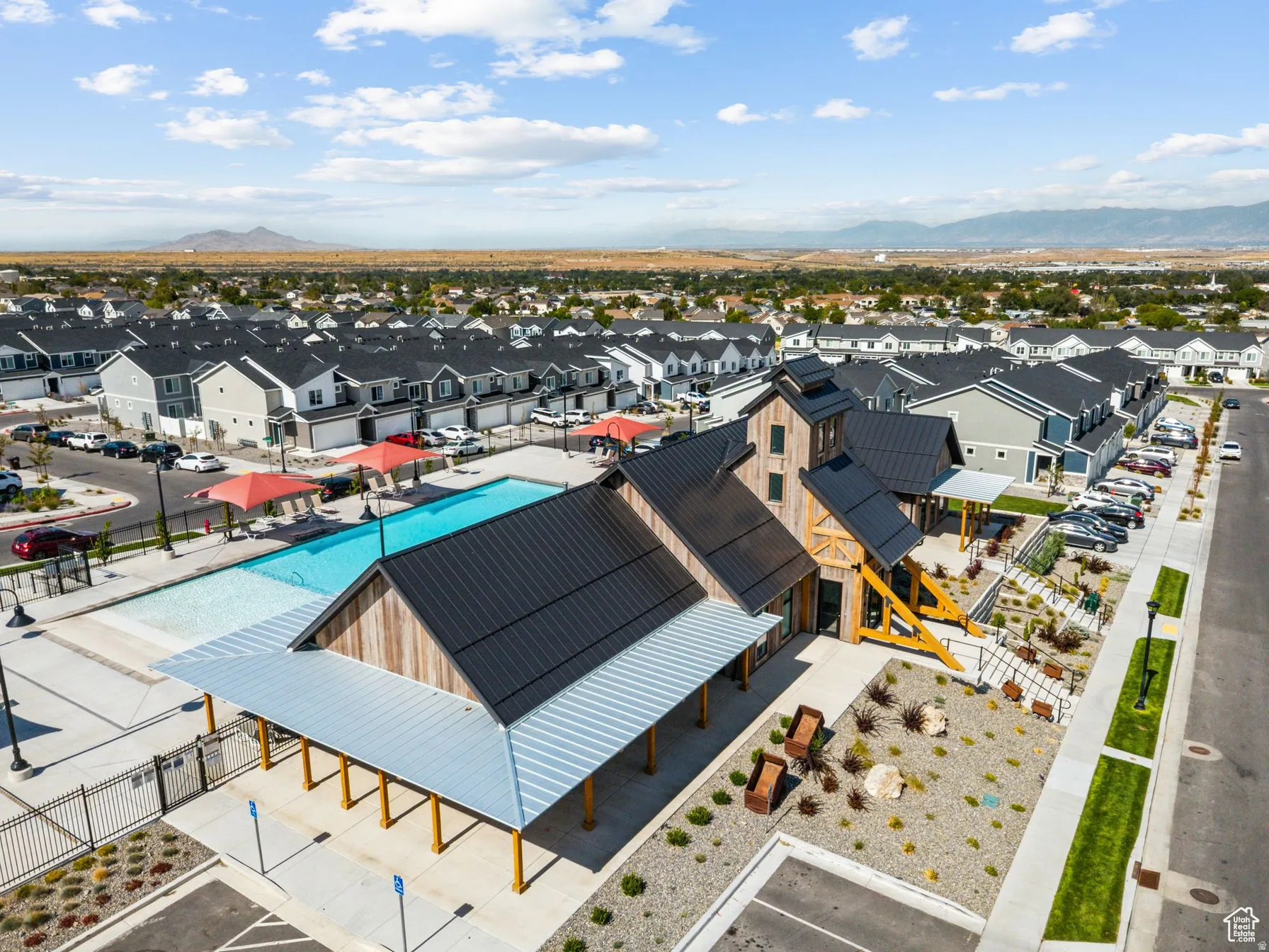 Aerial view of residential area featuring a mountain backdrop and a pool