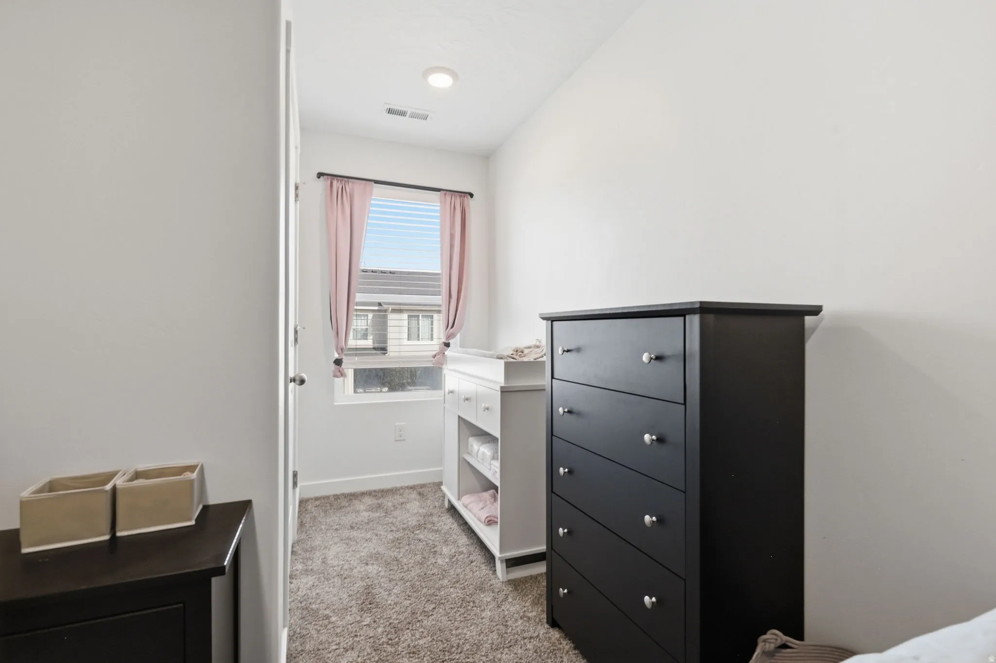 Bedroom featuring light carpet and baseboards