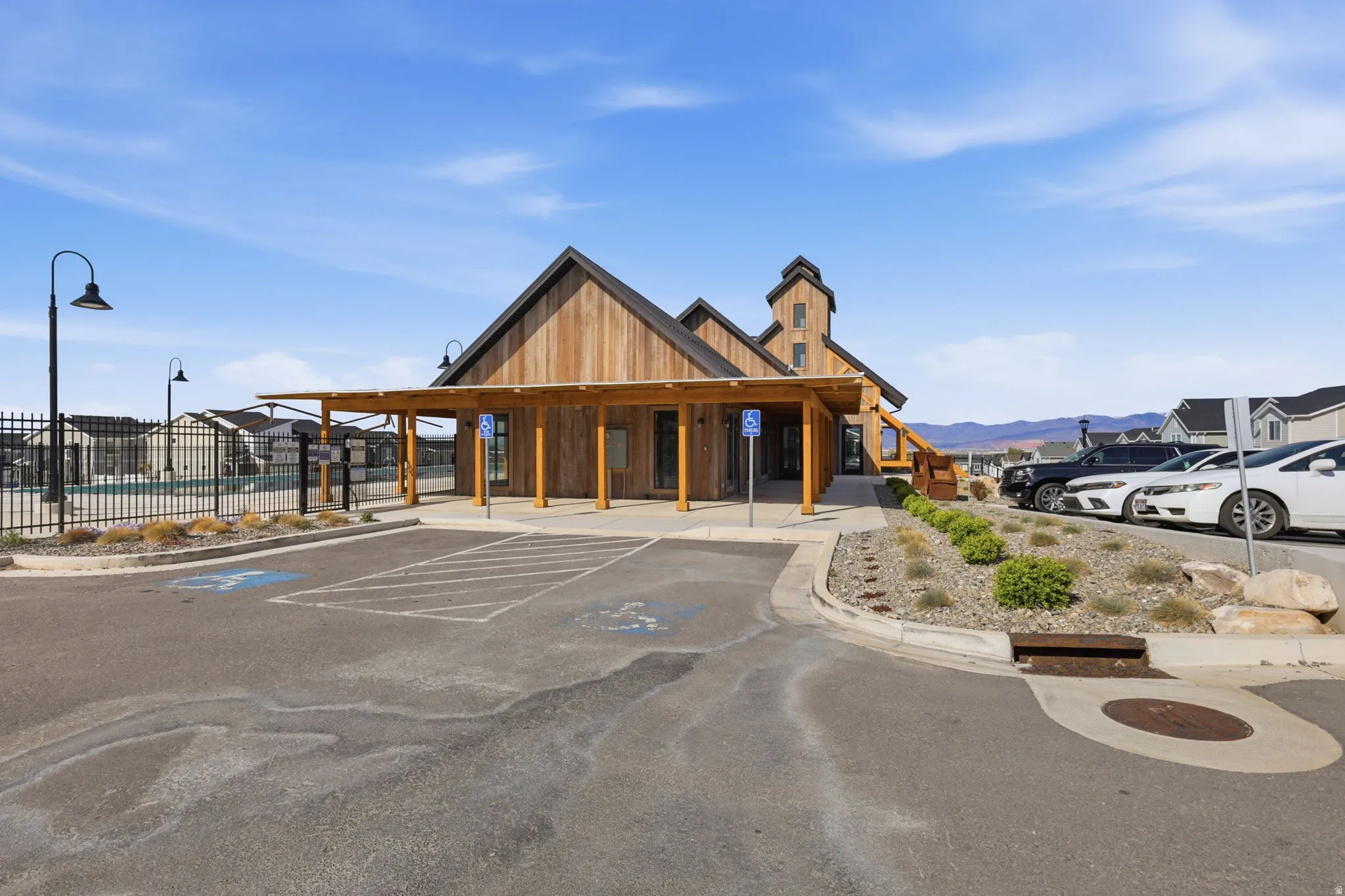 View of building exterior with uncovered parking and a pool