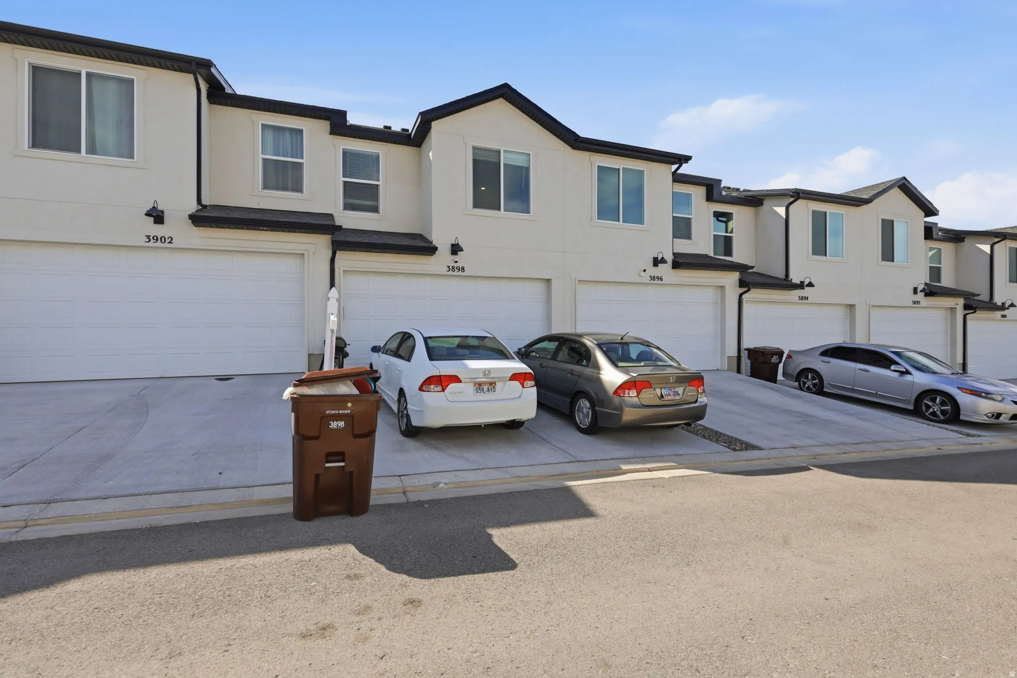 Traditional-style house with an attached garage, stucco siding, a residential view, and driveway
