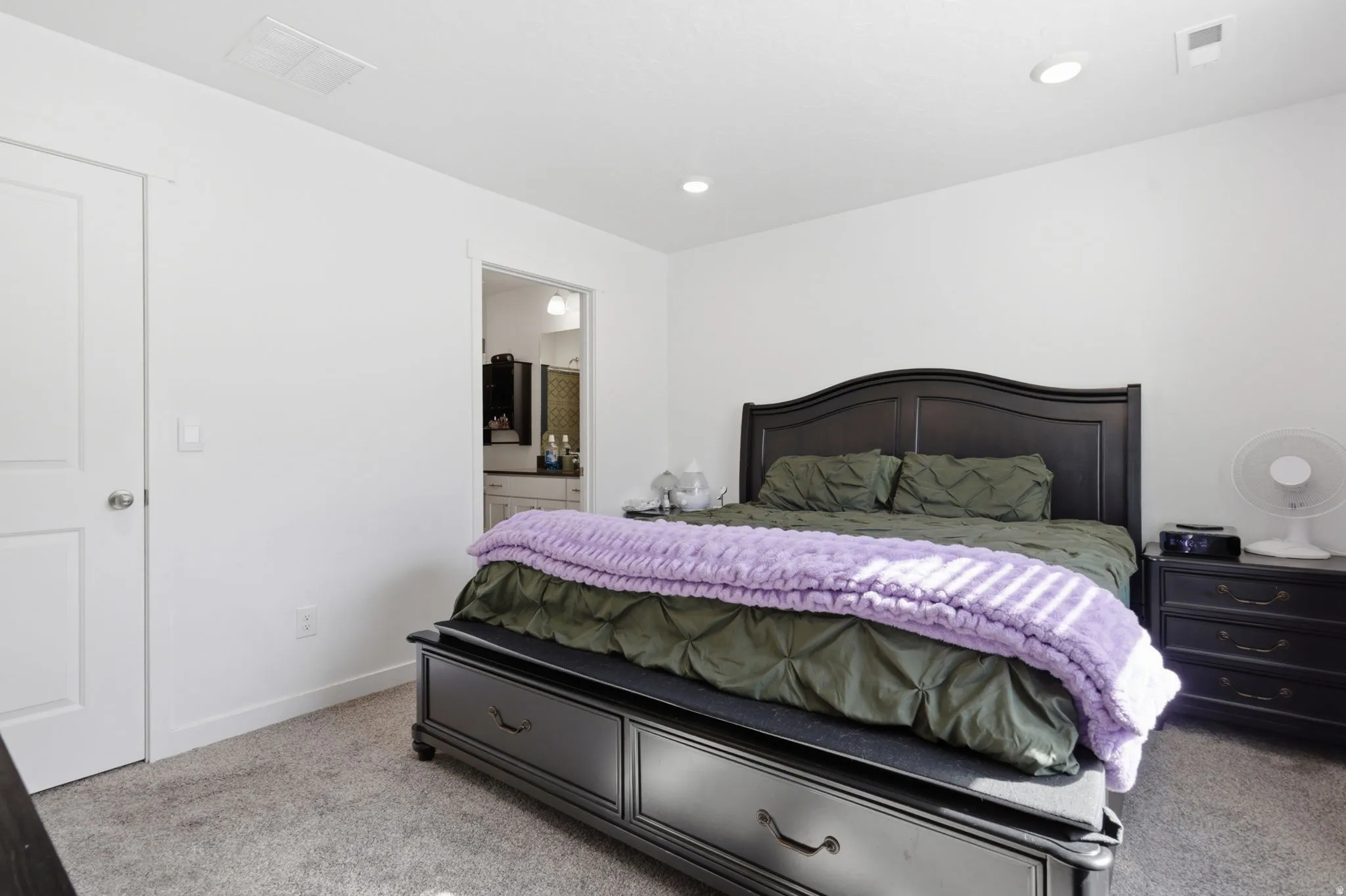 Bedroom featuring light carpet, connected bathroom, and recessed lighting