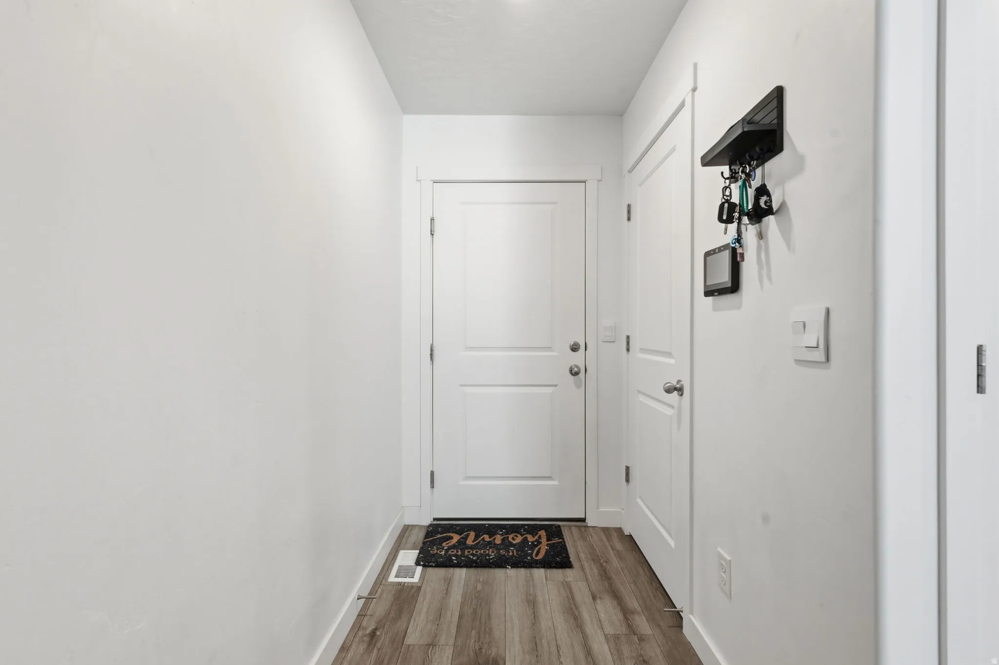Entryway with baseboards and wood finished floors