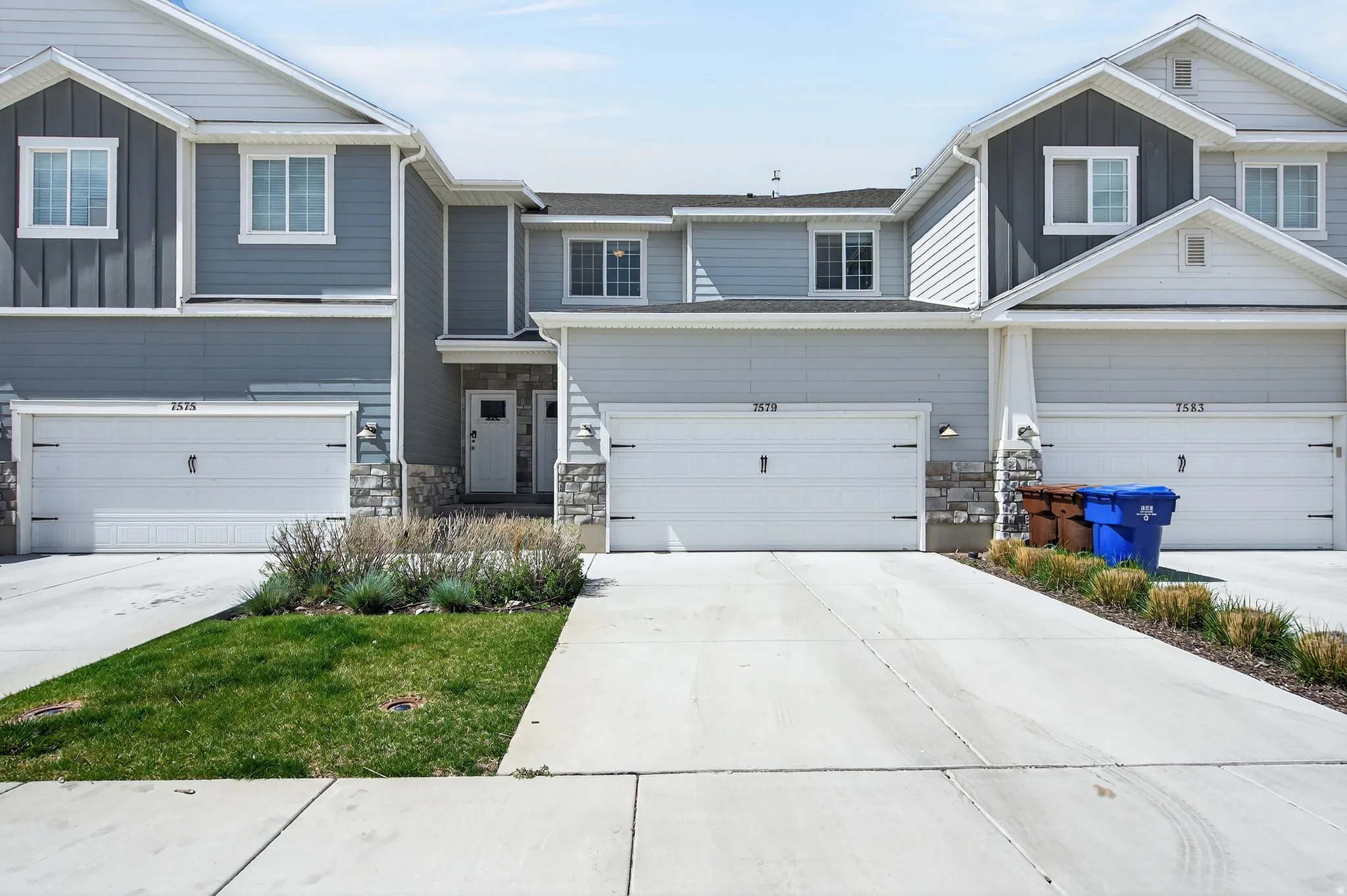 Craftsman-style house with board and batten siding, stone siding, concrete driveway, and a garage