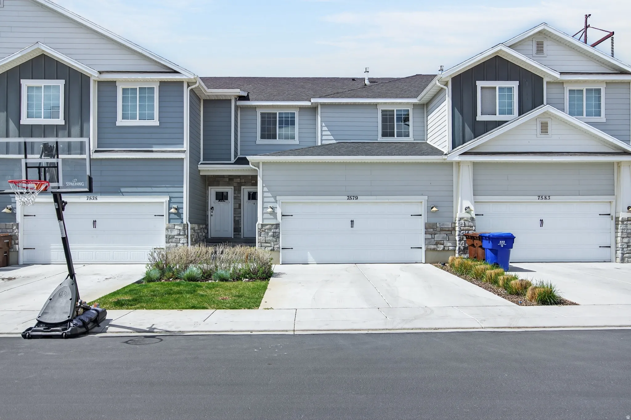 Craftsman-style home with board and batten siding, stone siding, concrete driveway, and an attached garage