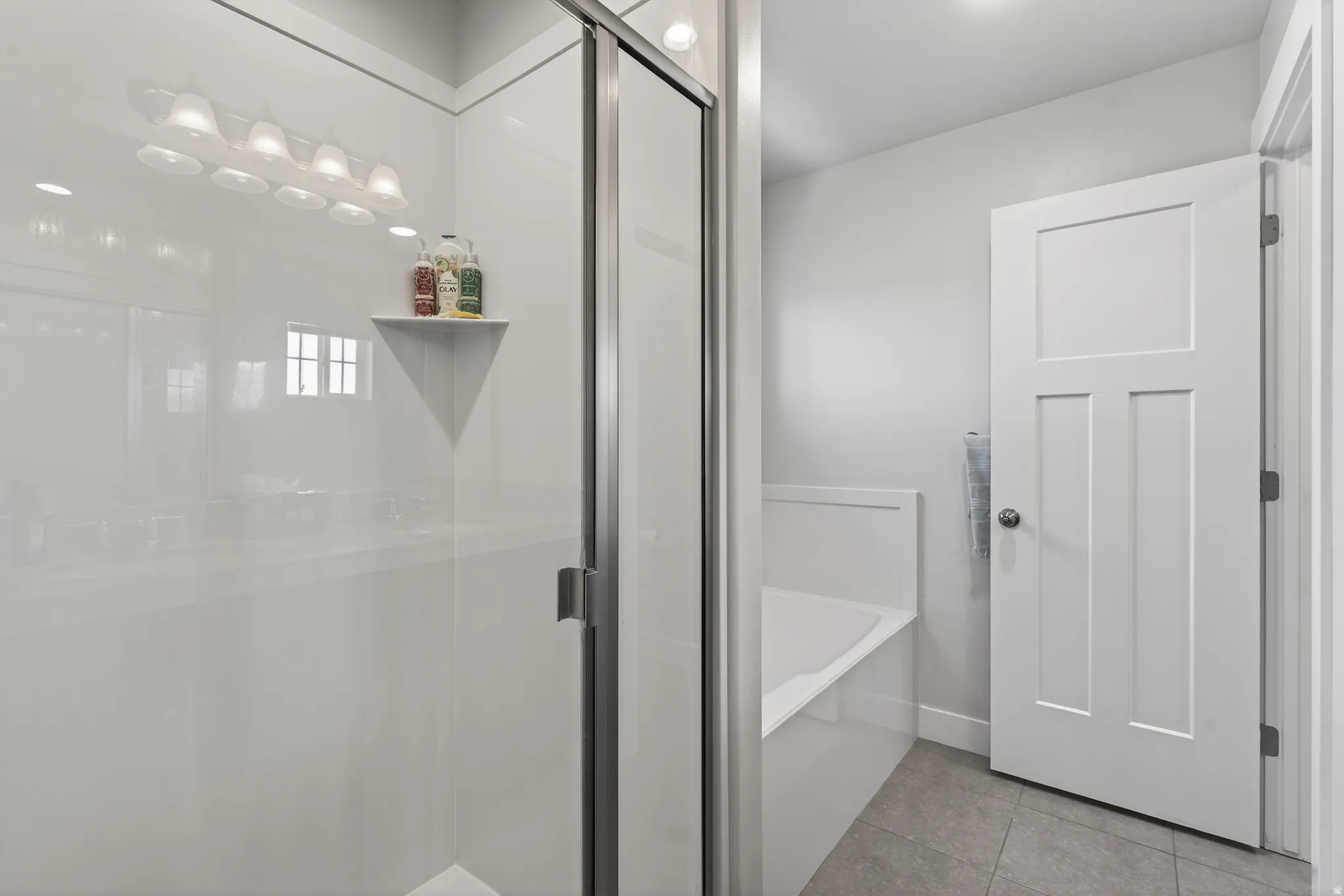 Full bath with a garden tub, a shower stall, and light tile patterned floors