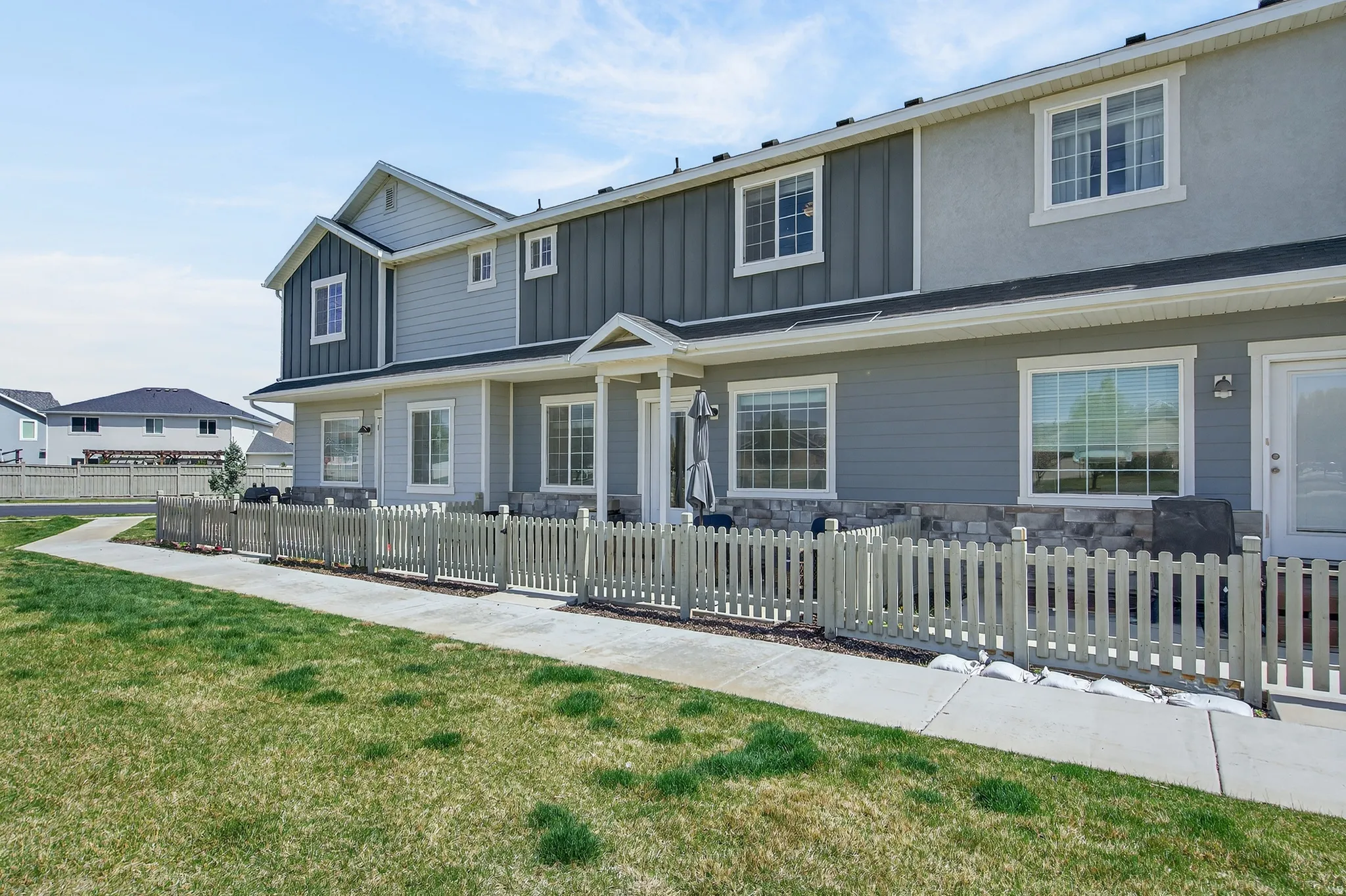 Traditional home featuring board and batten siding, stone siding, and a fenced front yard