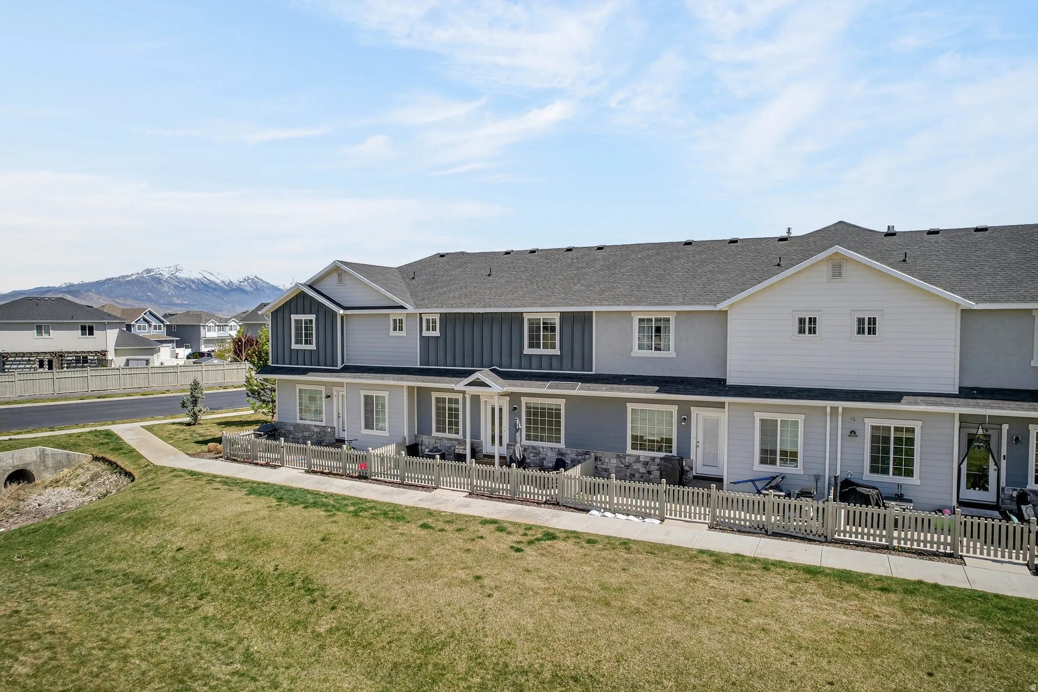 Back of house featuring a residential view, roof with shingles, board and batten siding, and a mountain view