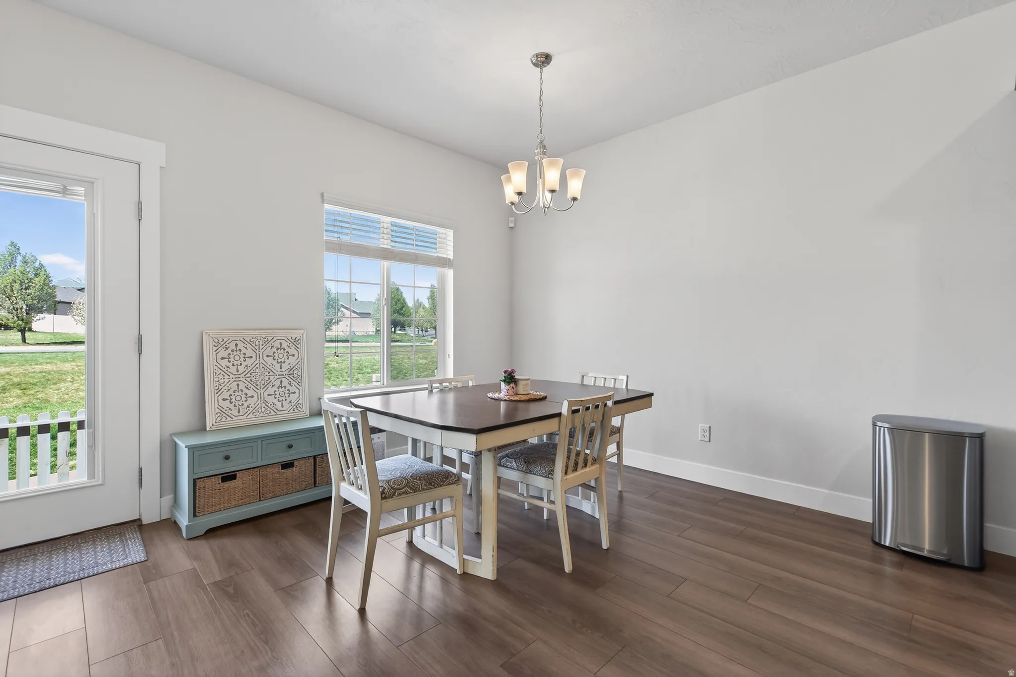 Dining area with dark wood-style floors and a chandelier