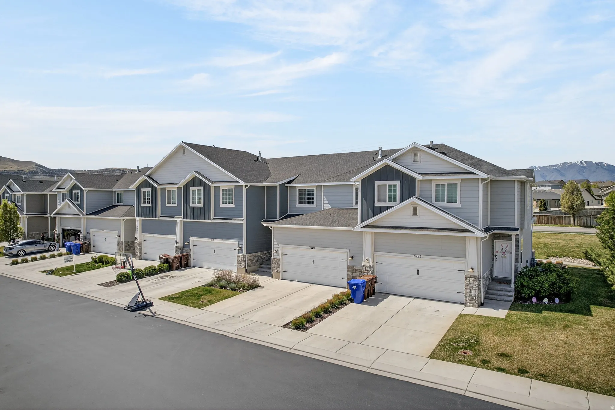 Craftsman-style home featuring a residential view, stone siding, board and batten siding, and concrete driveway