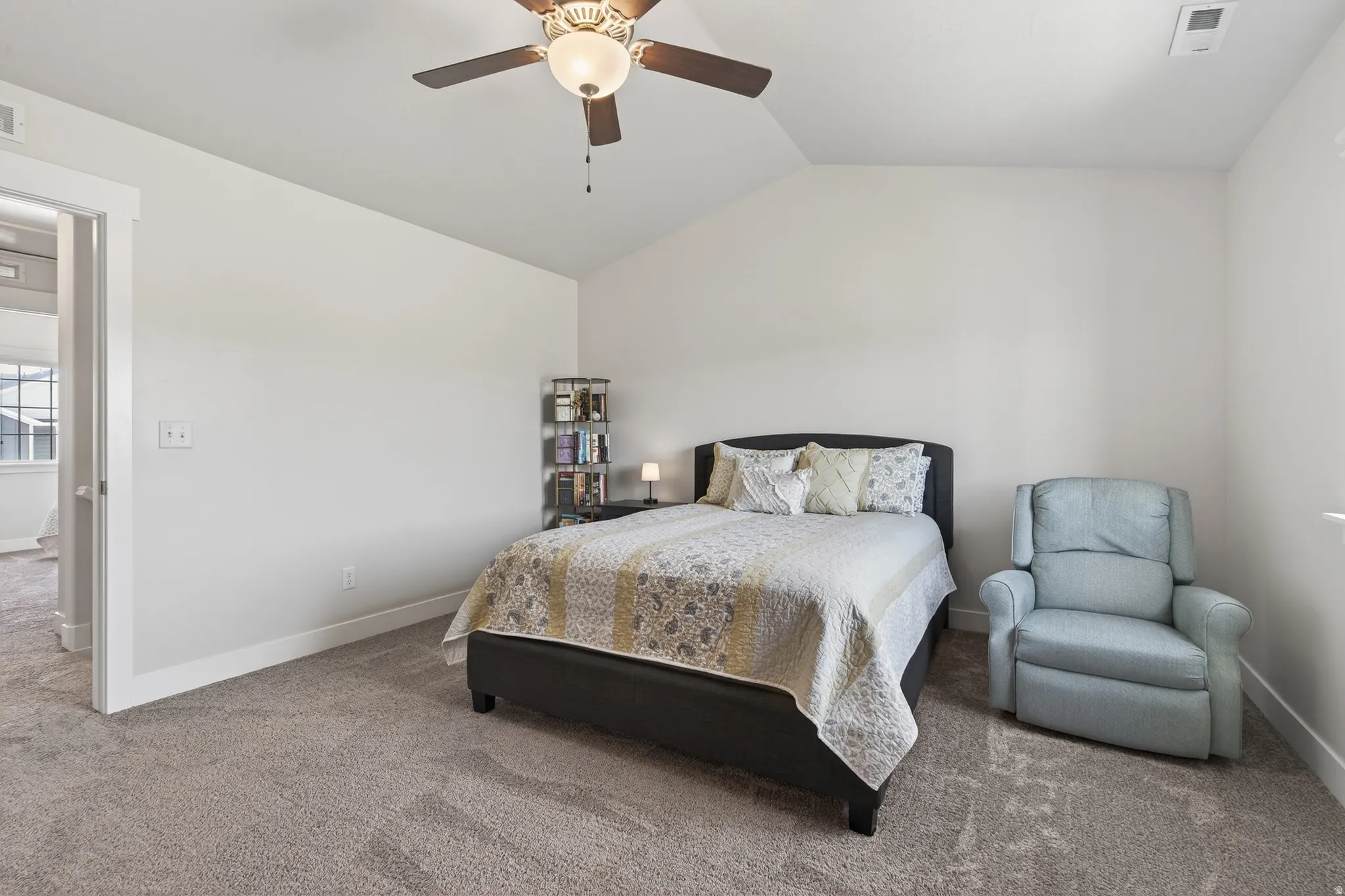 Bedroom with vaulted ceiling, carpet, and ceiling fan