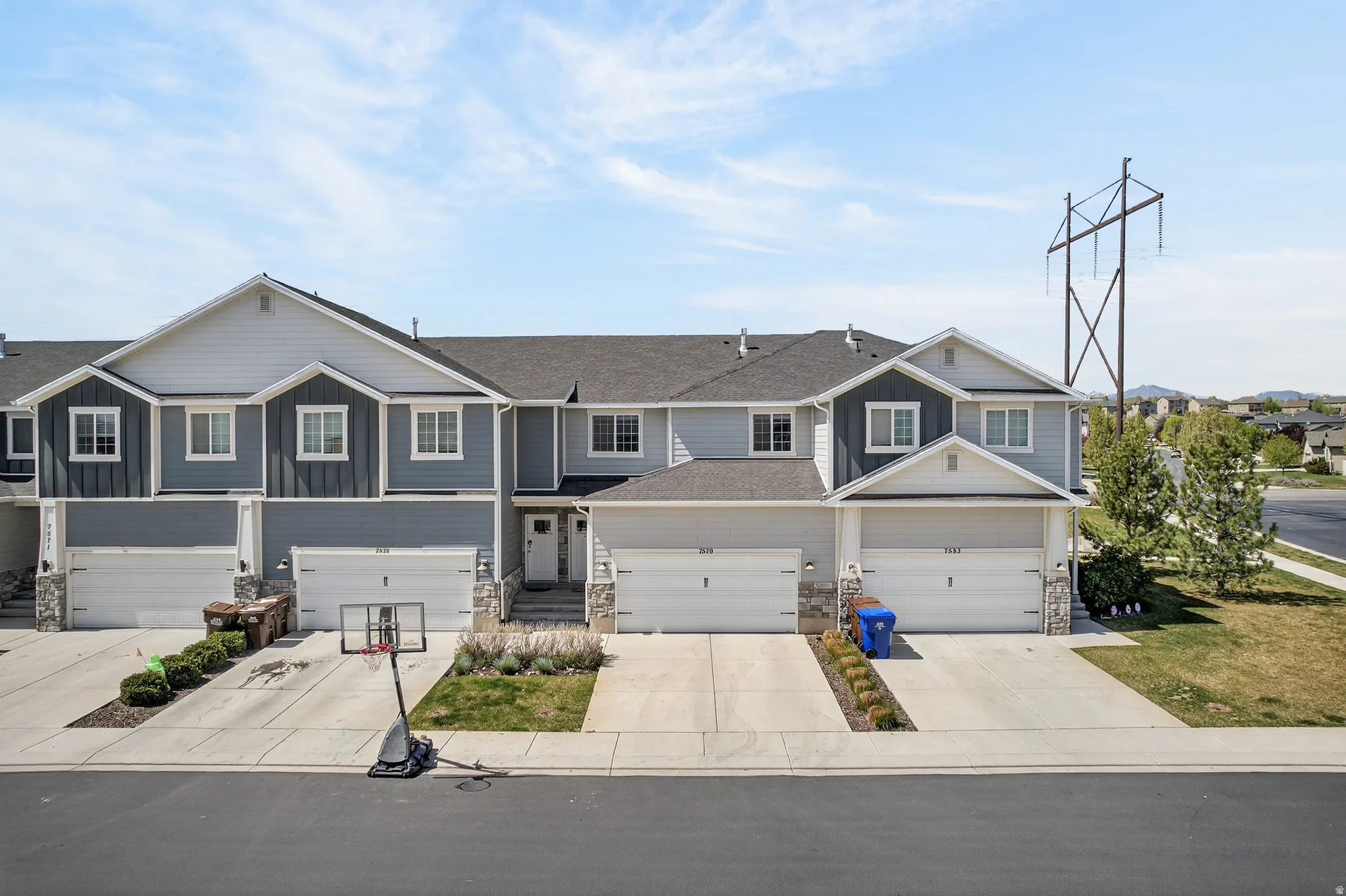 Craftsman-style house featuring stone siding, board and batten siding, concrete driveway, and an attached garage