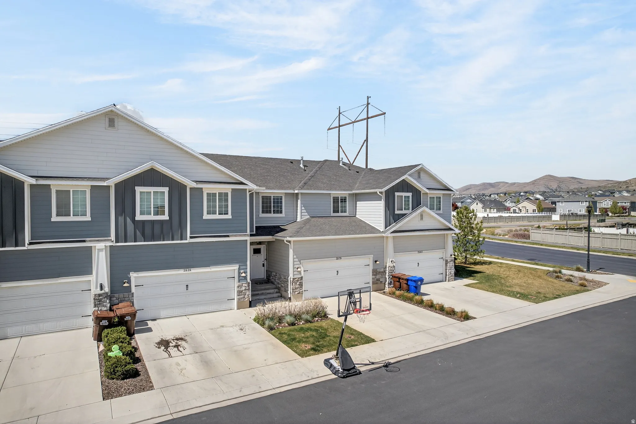 Craftsman-style home with a residential view, board and batten siding, concrete driveway, stone siding, and an attached garage
