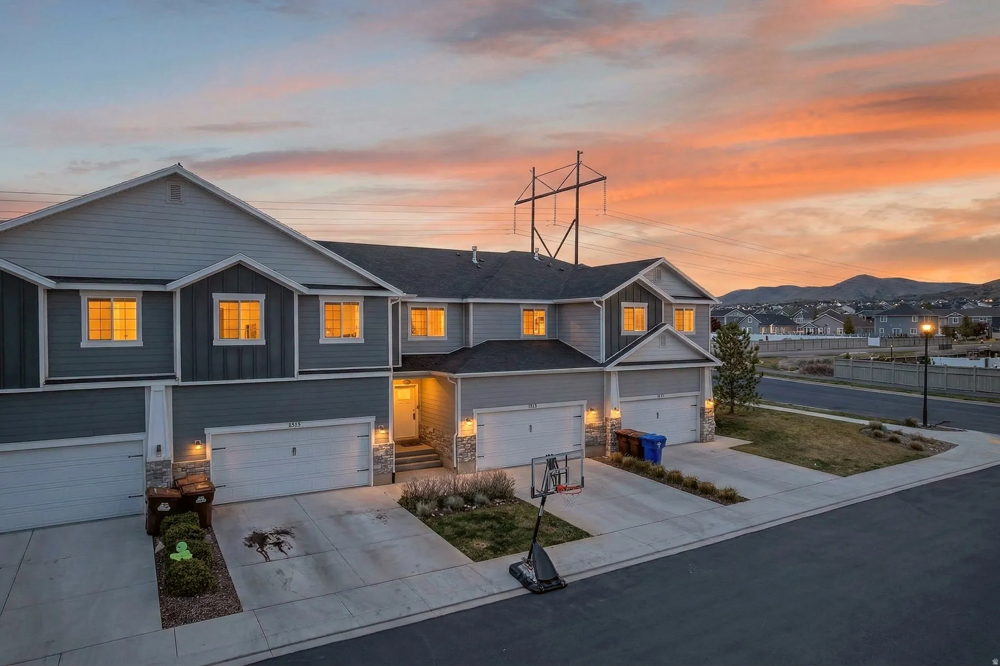 View of front of home featuring stone siding, concrete driveway, board and batten siding, an attached garage, and a residential view