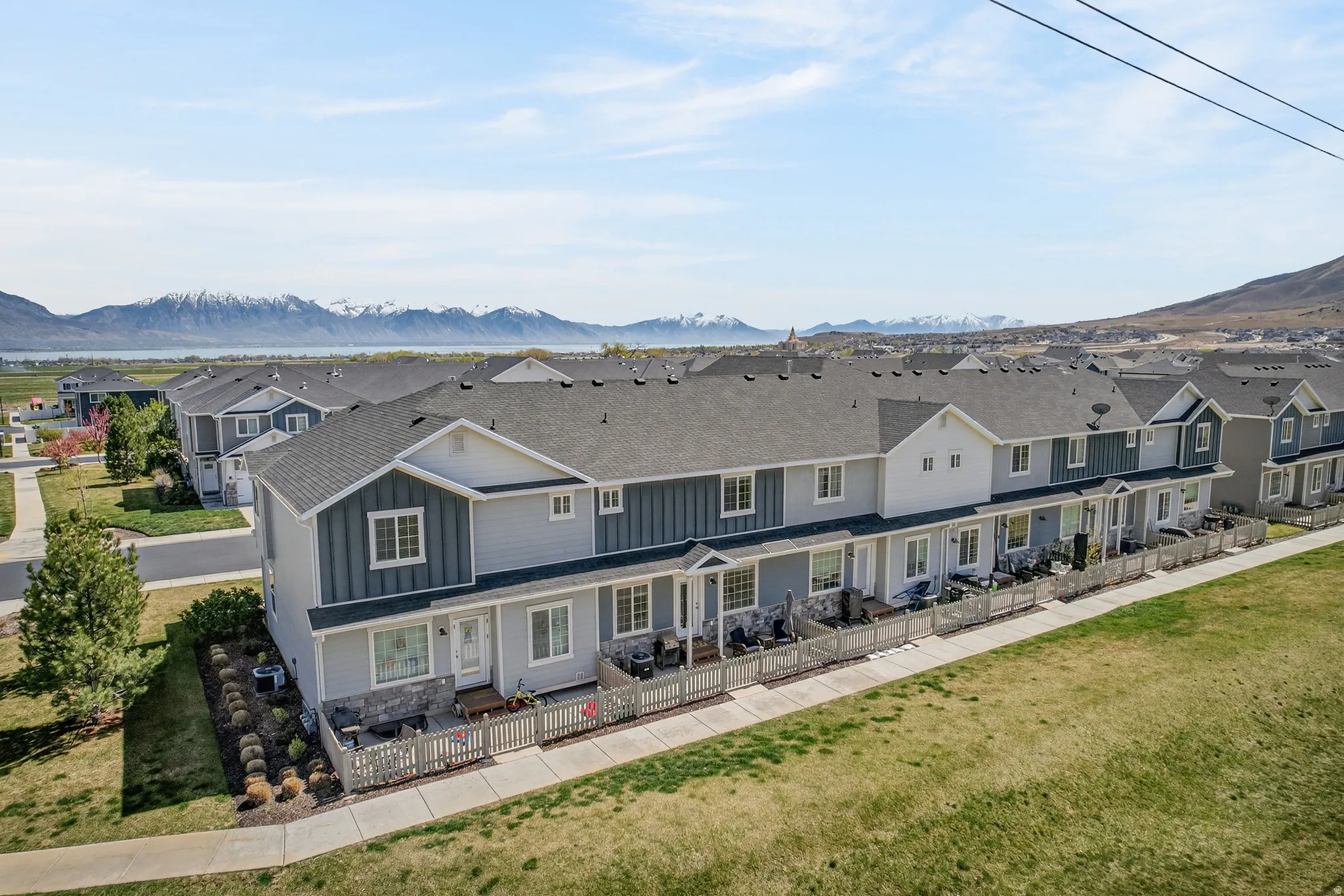 Back of property with a residential view, board and batten siding, a mountain view, a patio, and roof with shingles