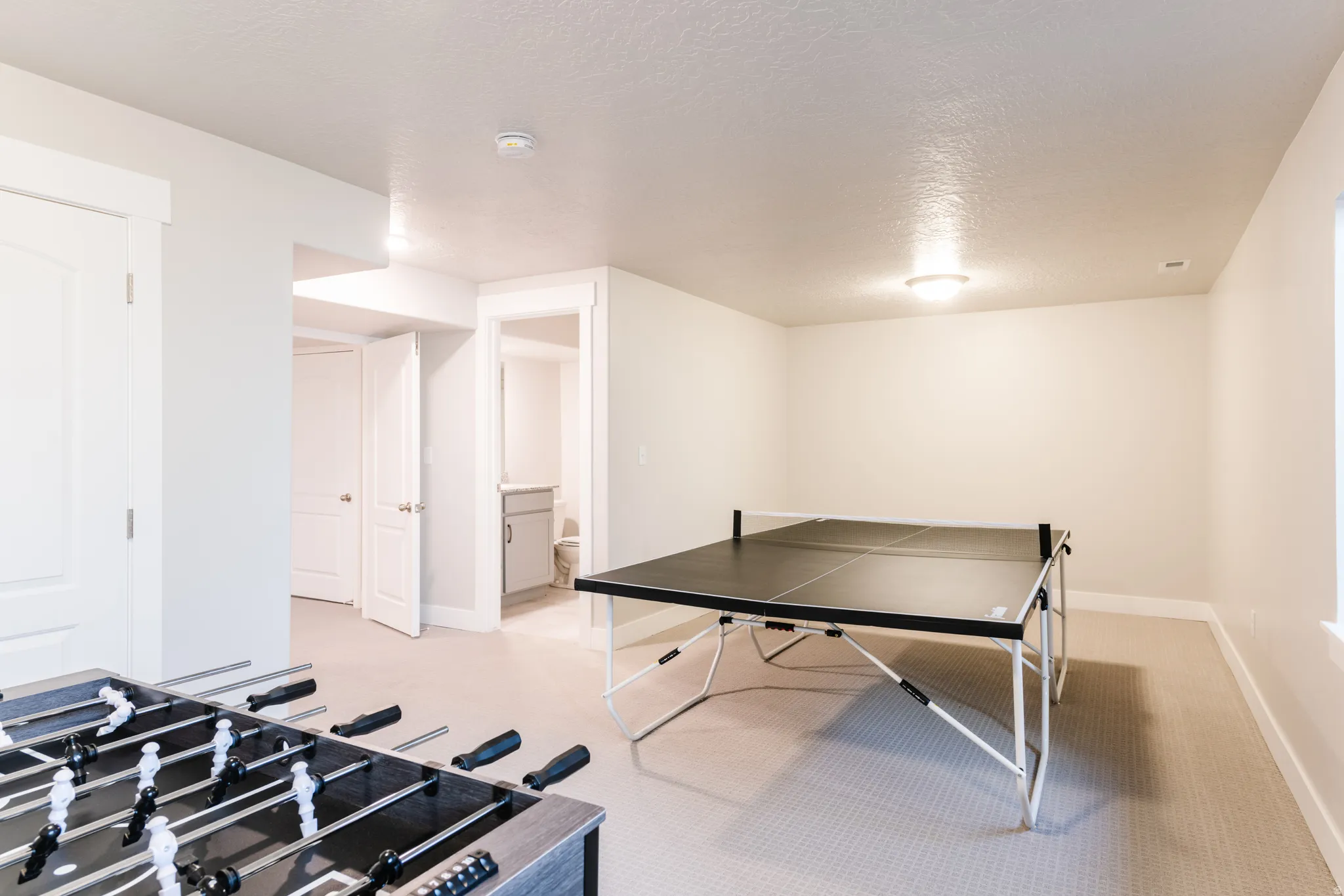 Playroom featuring a textured ceiling and light colored carpet