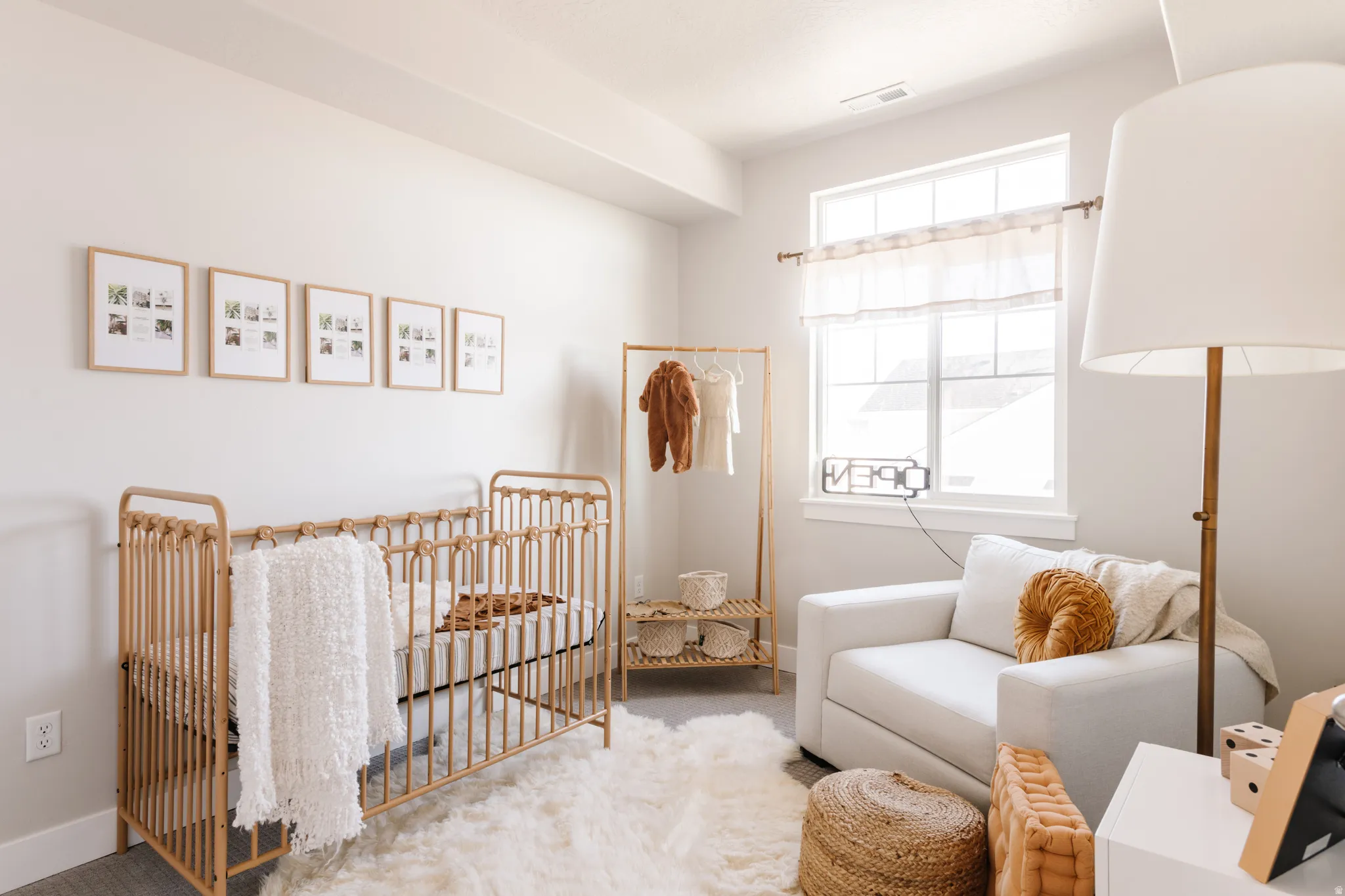 Bedroom featuring light colored carpet and a crib