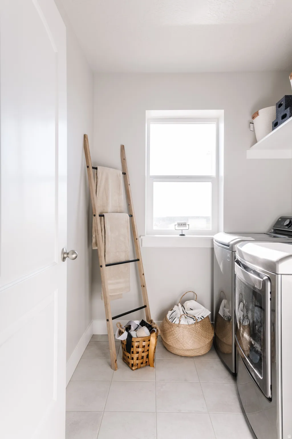 Laundry room with light tile patterned floors and washer and clothes dryer