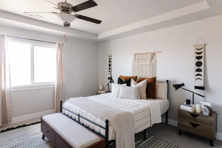 Bedroom with a textured ceiling, a tray ceiling, and a ceiling fan