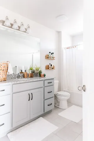 Bathroom featuring vanity, shower / tub combo with curtain, and light tile patterned flooring