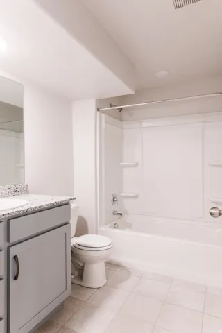 Full bathroom with vanity, shower / bath combination, and light tile patterned floors