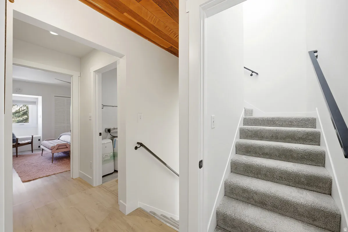 Stairway with wood finished floors and baseboards