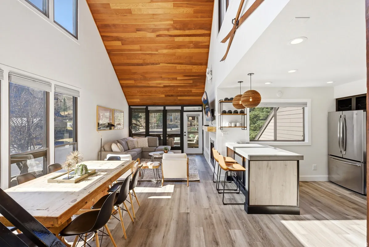 Dining space featuring light wood-style flooring, a vaulted wooden ceiling, and a fireplace