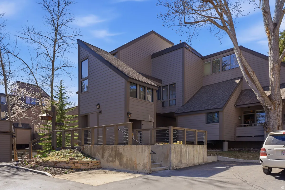View of front of house featuring roof with shingles and stairs