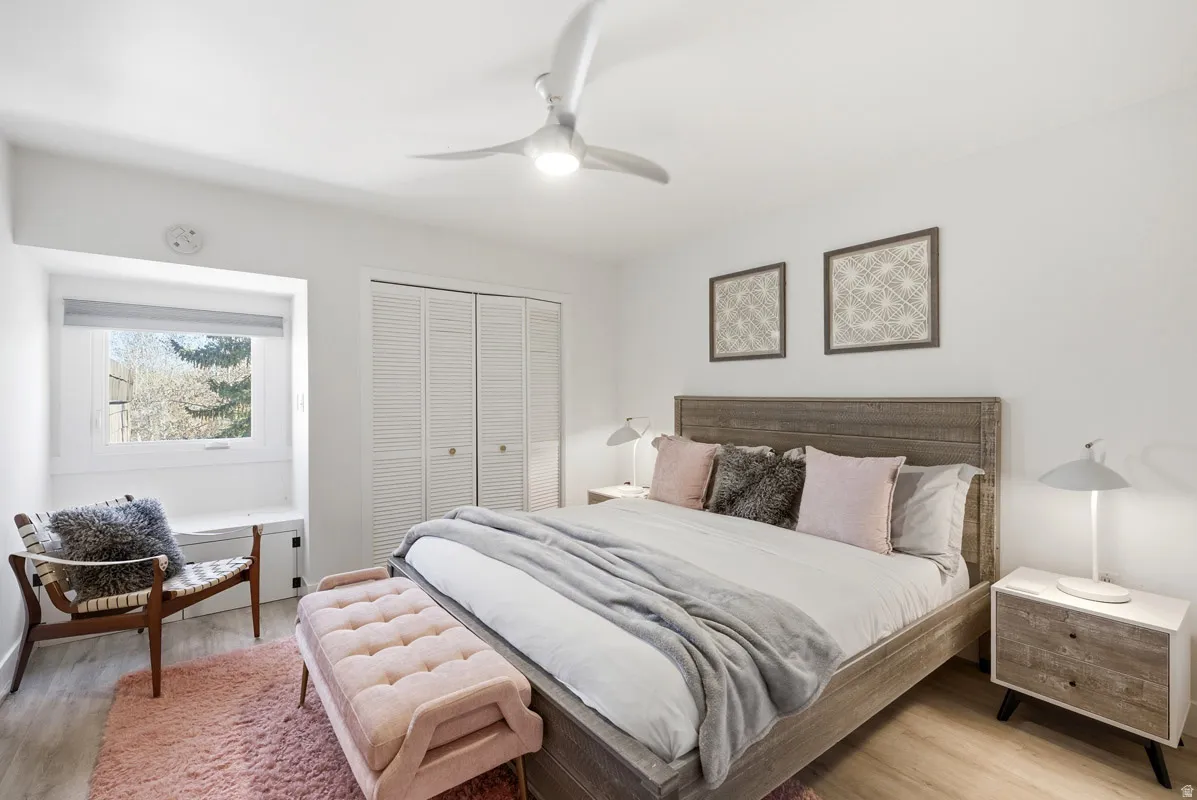 Bedroom with light wood-type flooring, a closet, and a ceiling fan