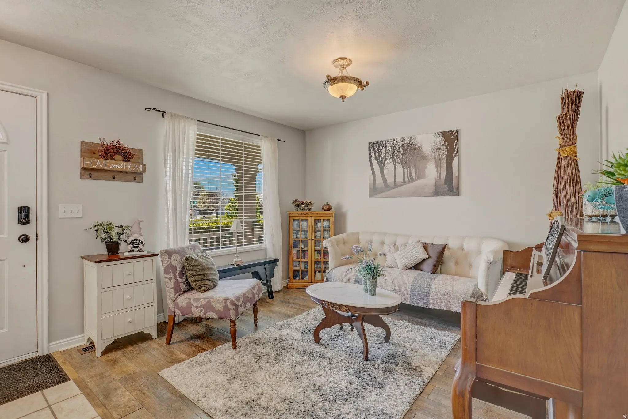 Living area featuring light wood-type flooring and a textured ceiling