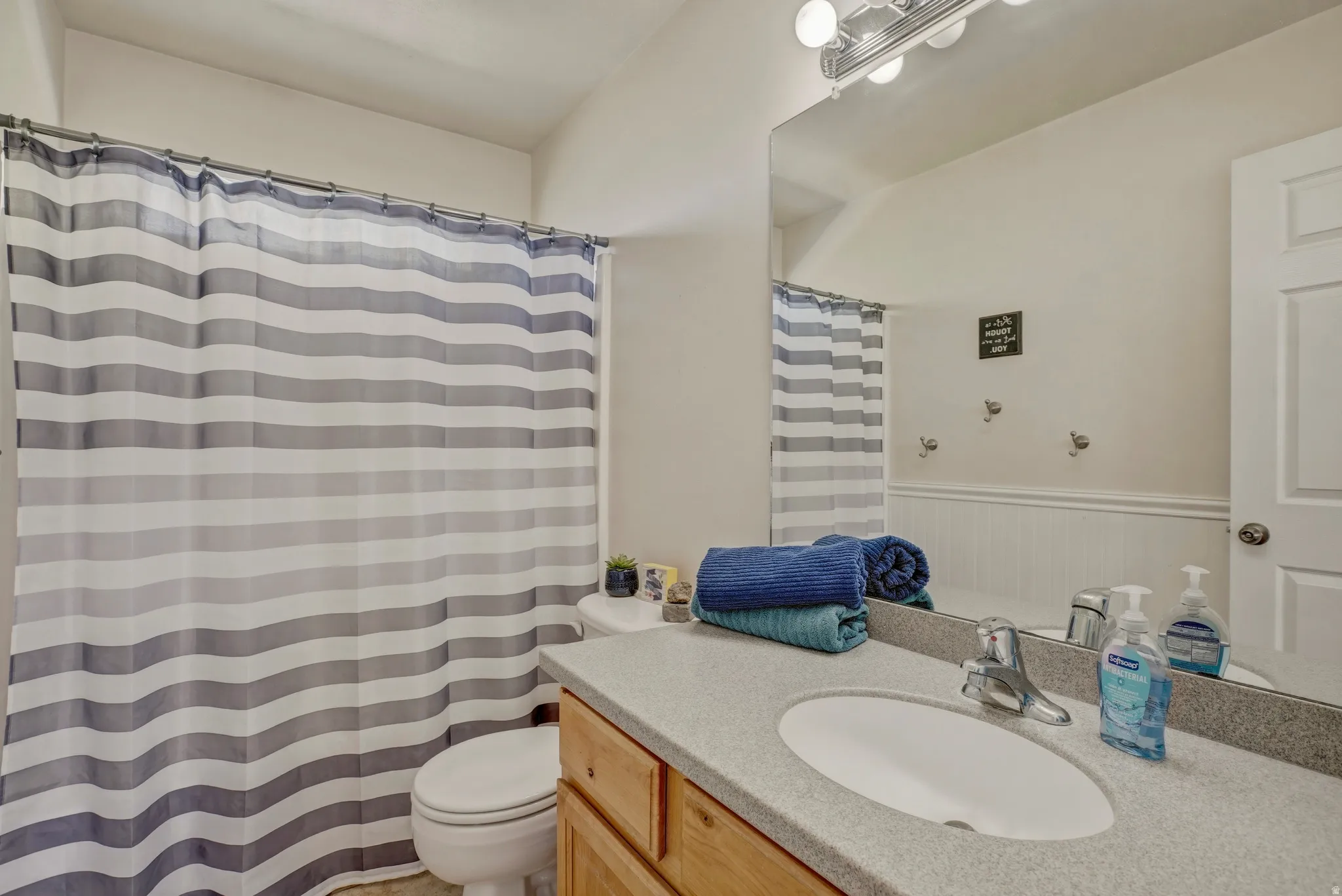 Bathroom featuring vanity, wainscoting, and a shower with curtain