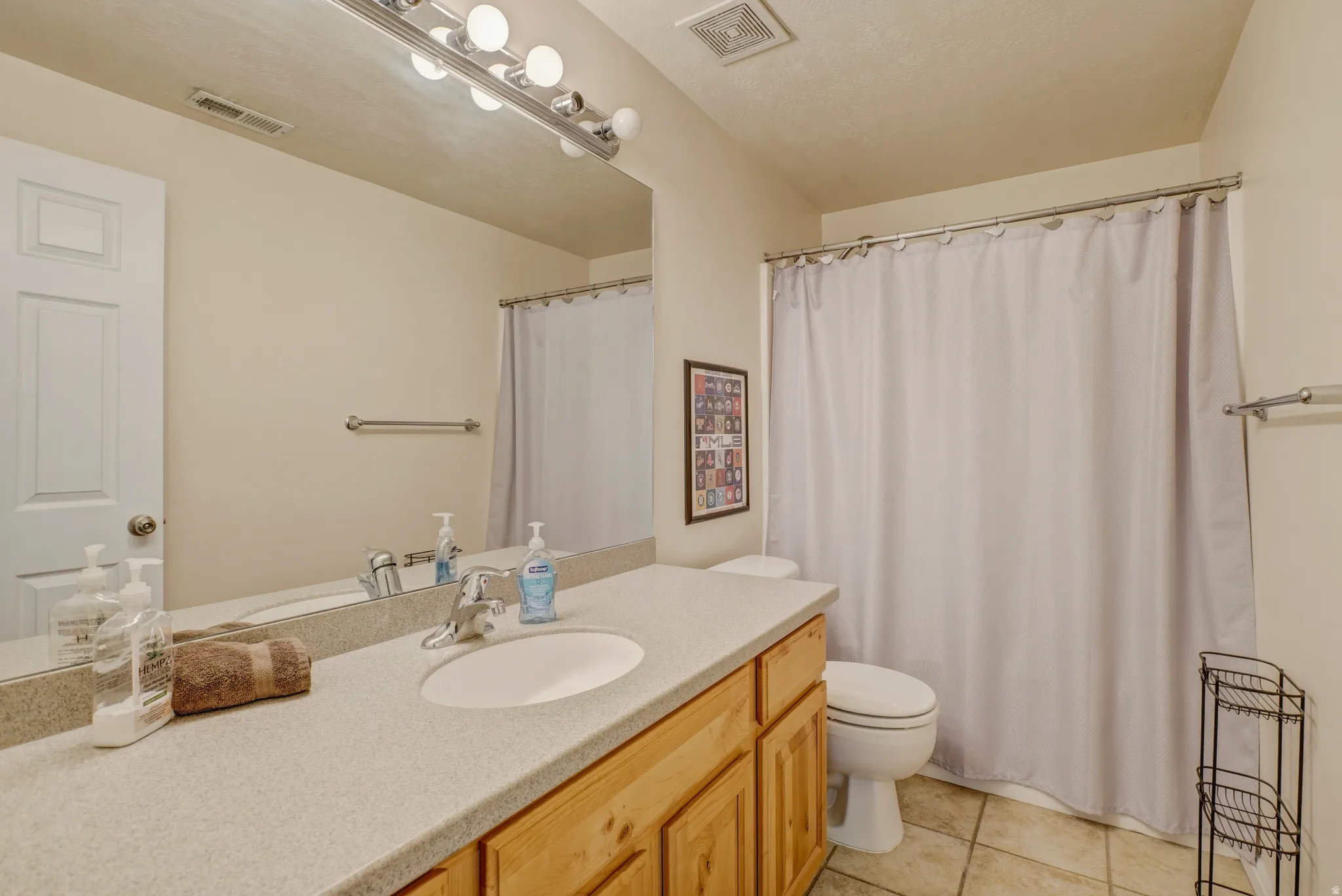 Bathroom featuring vanity, a shower with shower curtain, and light tile patterned floors
