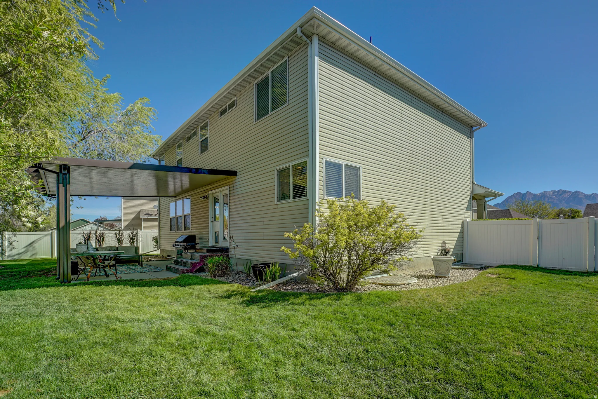 Back of property featuring a fenced backyard, a patio area, a mountain view, and a gate