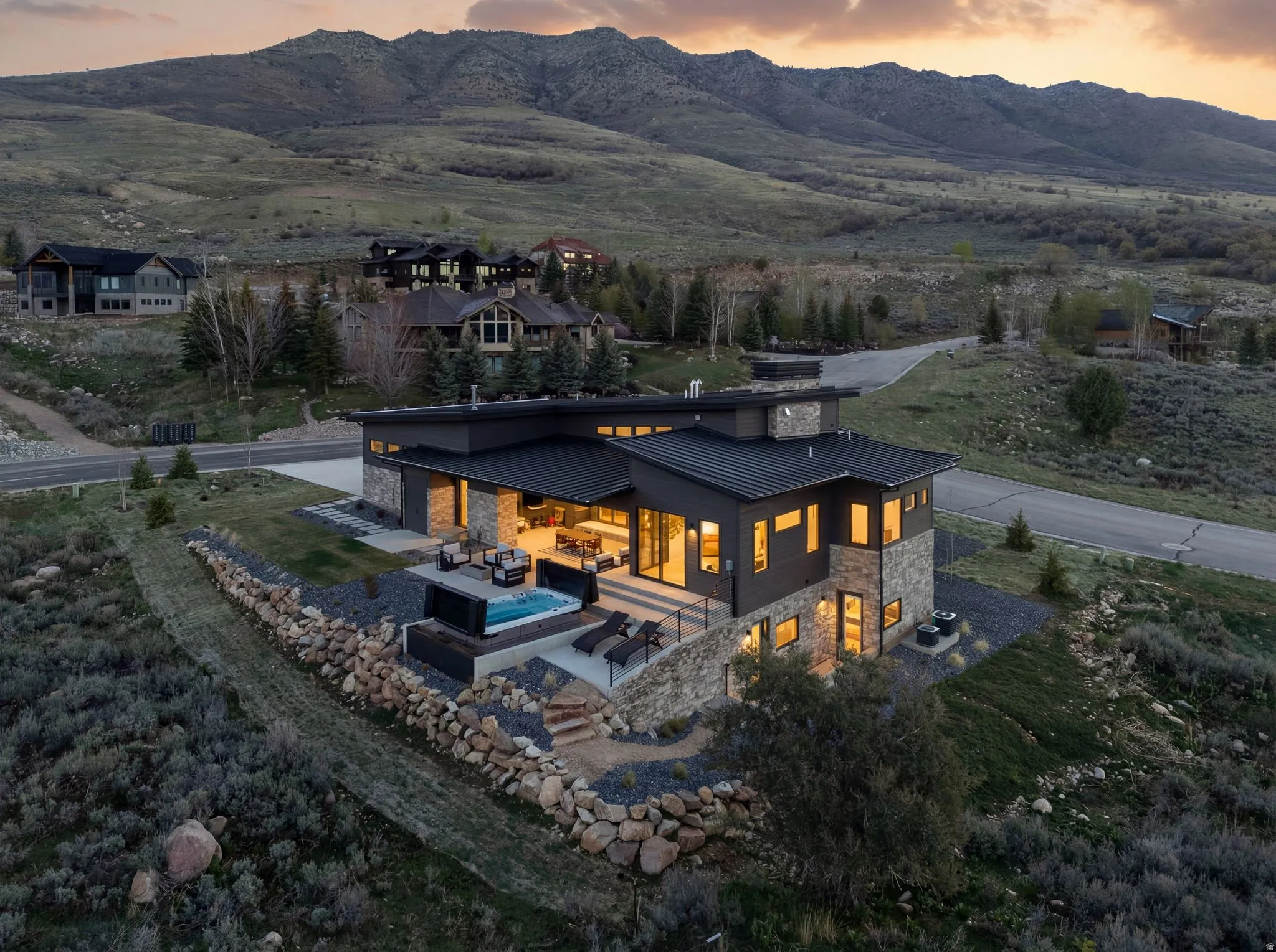Back of house featuring stone siding, a patio area, a standing seam roof, outdoor lounge area, and a mountain view
