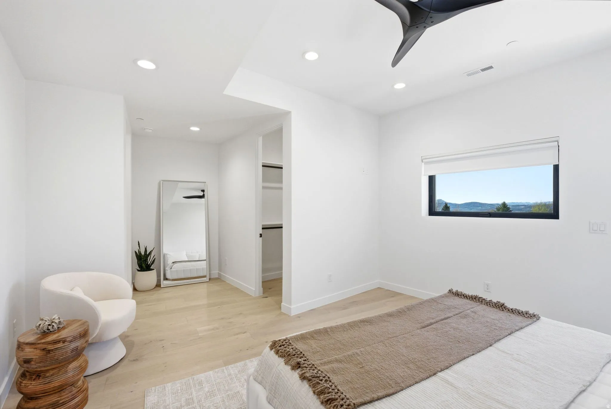 Bedroom with light wood-type flooring, recessed lighting, a ceiling fan, and a walk in closet
