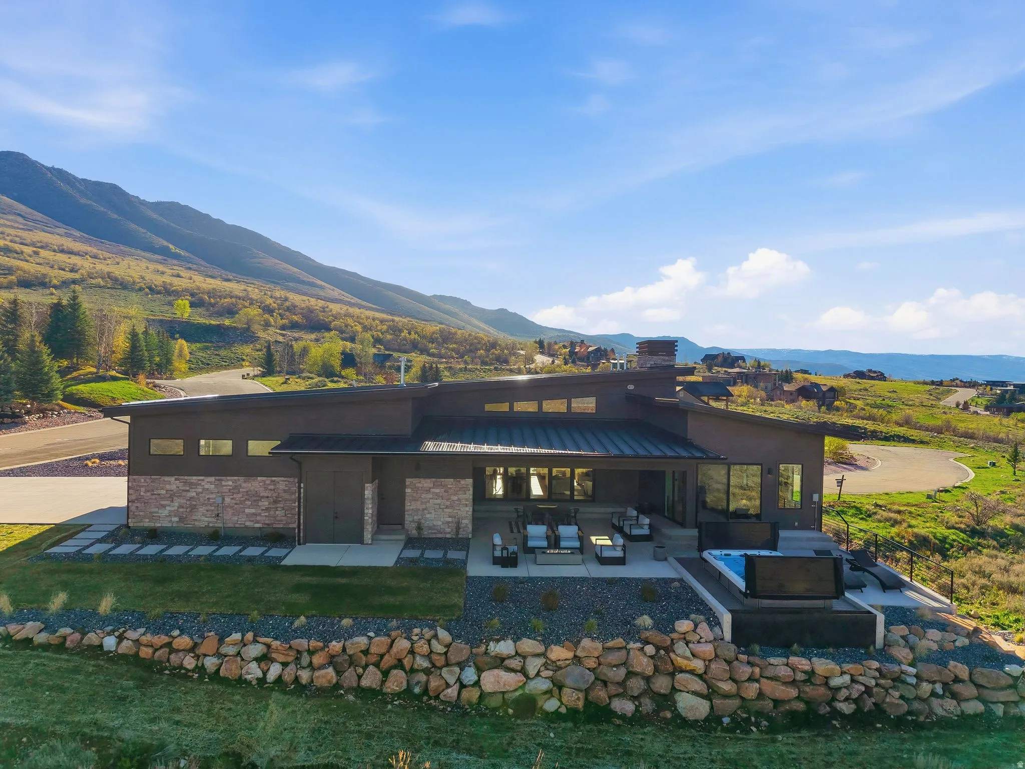Rear view of property with a chimney, a patio area, a mountain view, brick siding, and an outdoor living space