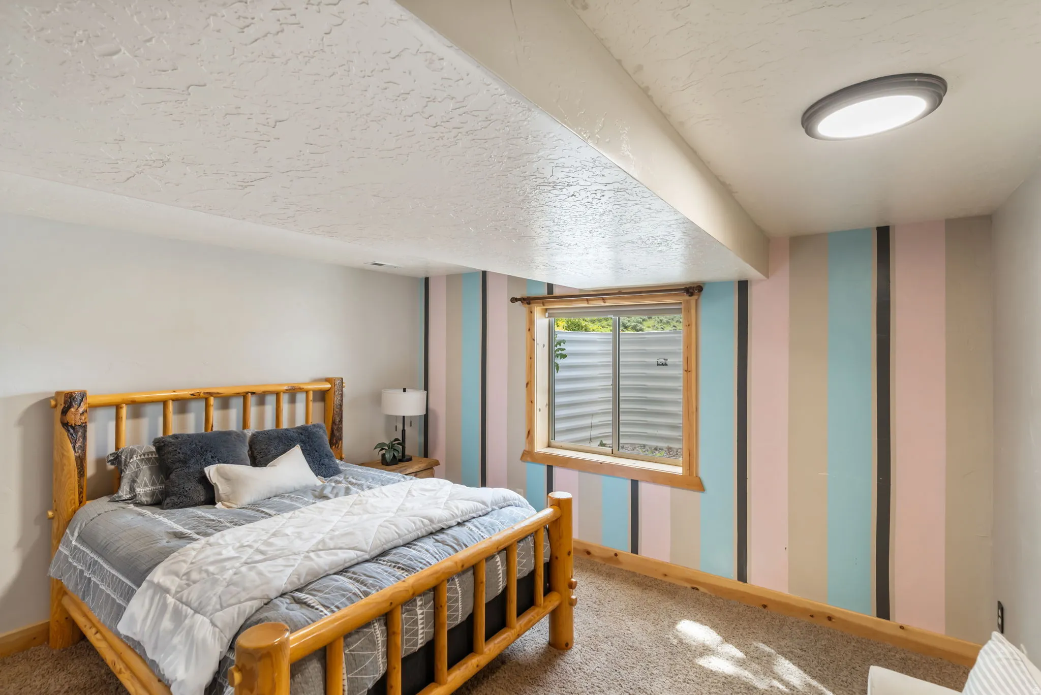 Carpeted bedroom with wallpapered walls and a textured ceiling