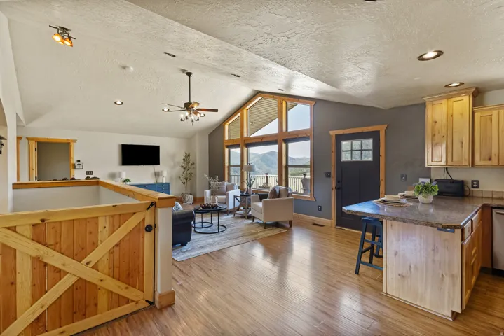 Kitchen with open floor plan, a peninsula, a breakfast bar, a ceiling fan, and a textured ceiling