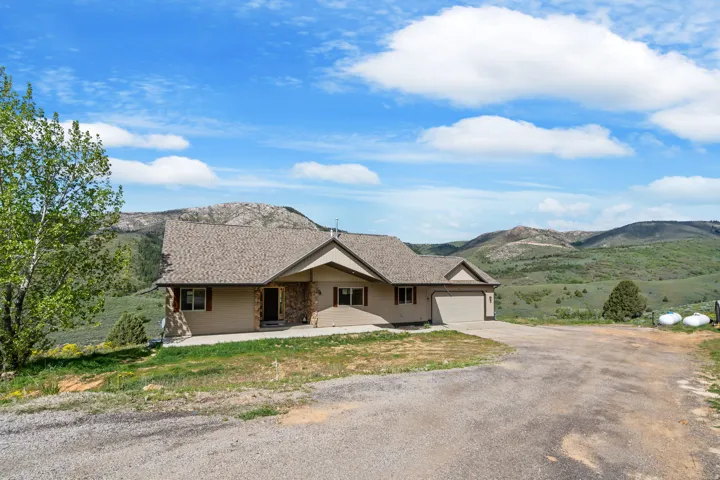 Single story home with driveway, a mountain view, and an attached garage