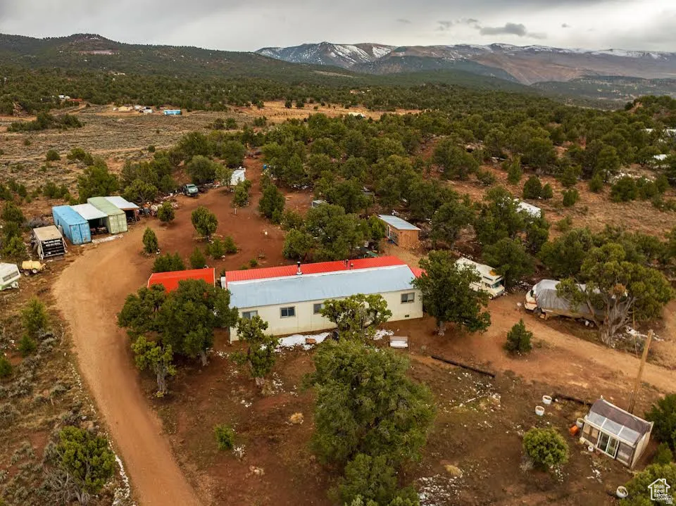 Aerial view of property's location featuring a mountain backdrop and rural landscape