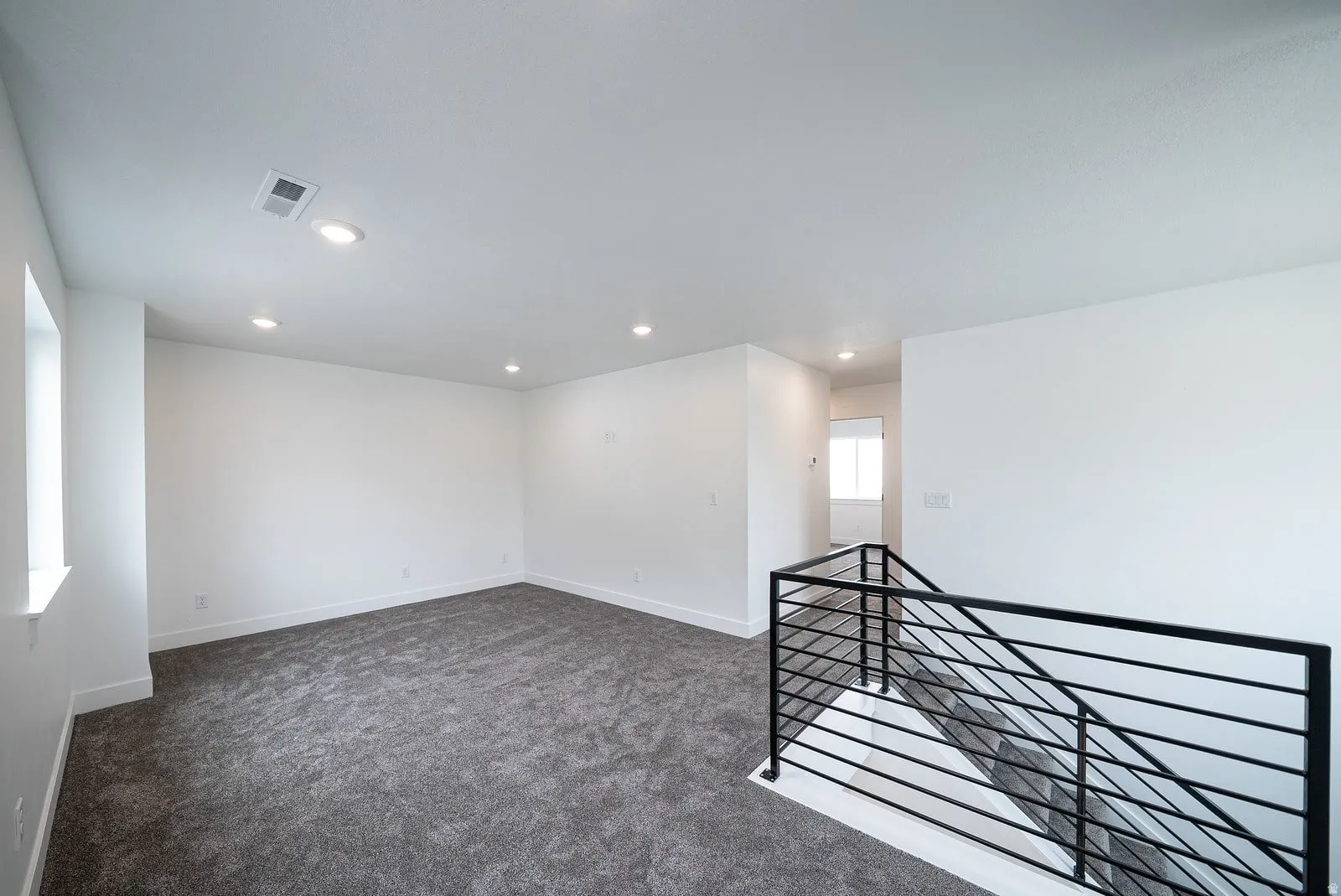 Spare room featuring dark carpet and recessed lighting