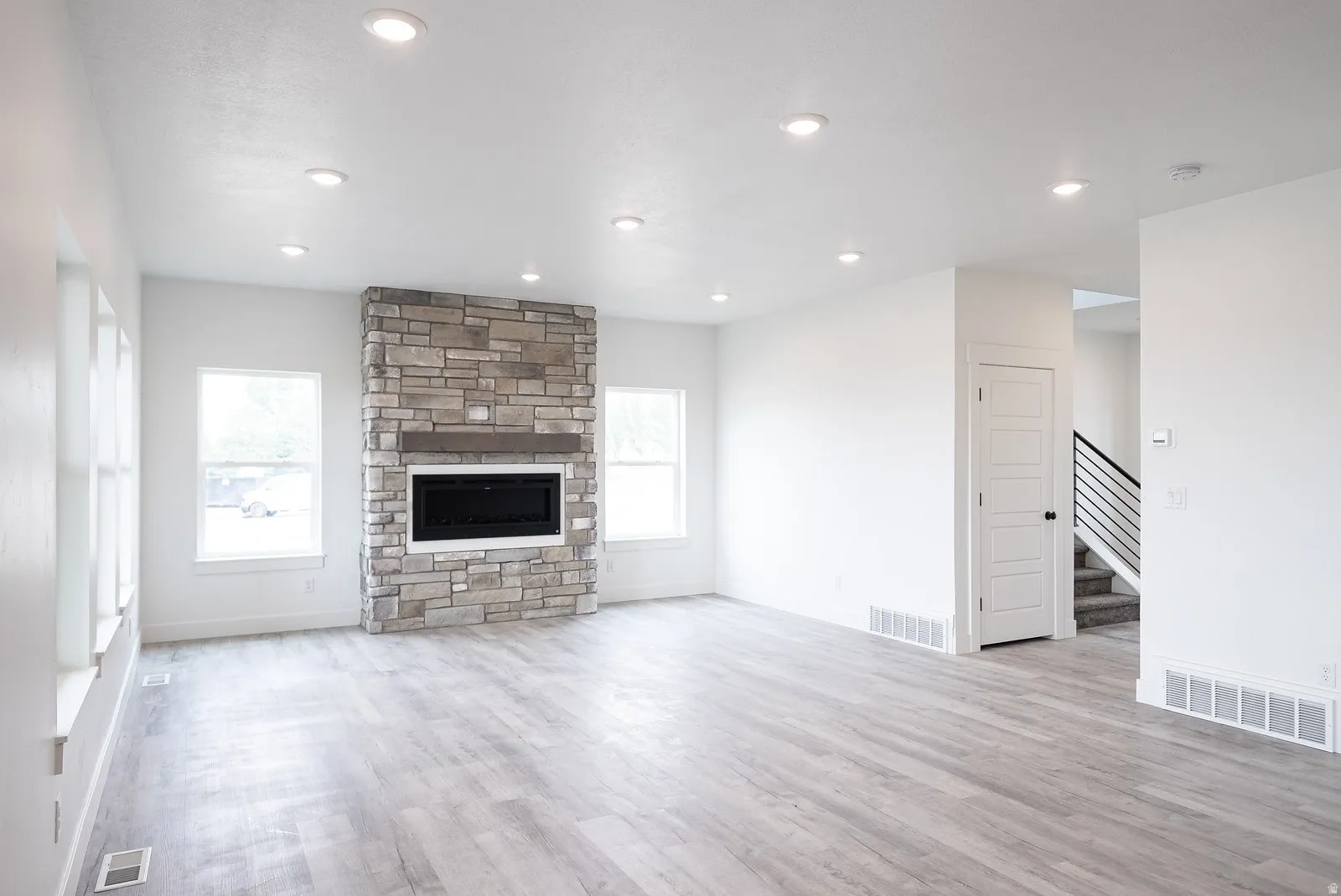 Unfurnished living room with light wood-style flooring, a fireplace, and recessed lighting