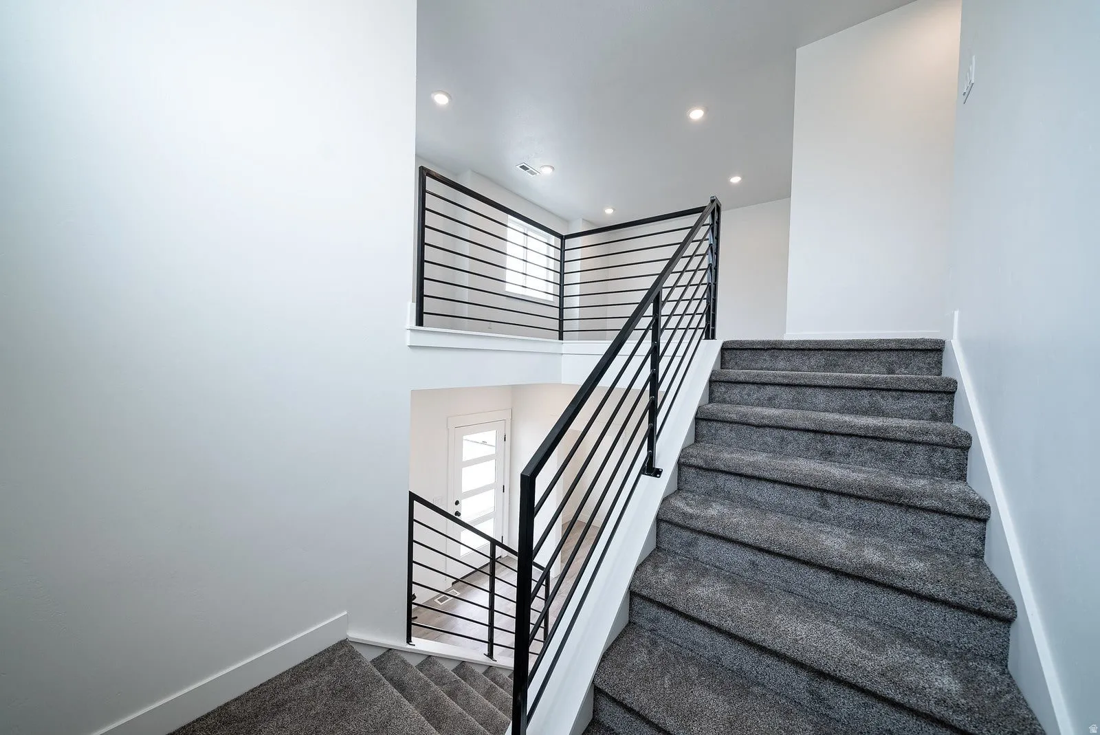 Staircase with a high ceiling, recessed lighting, and carpet