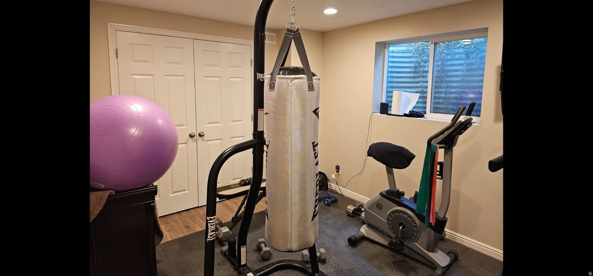 Workout area featuring light wood-style floors and recessed lighting